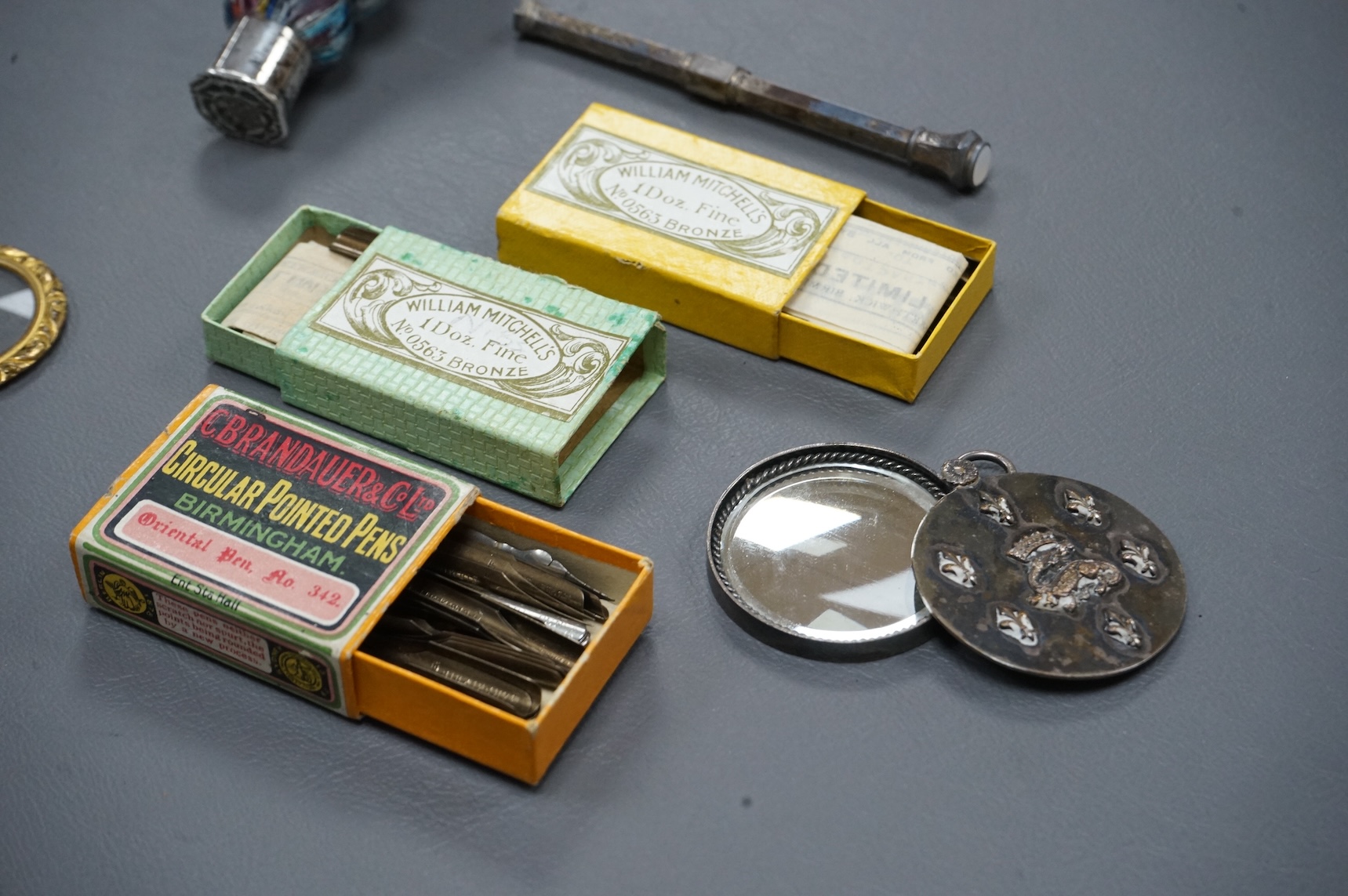 A small collection of objects to include a 17th century? French multi-cane glass seal, miniature white metal mirror and boxed pen nibs, seal 8cm high